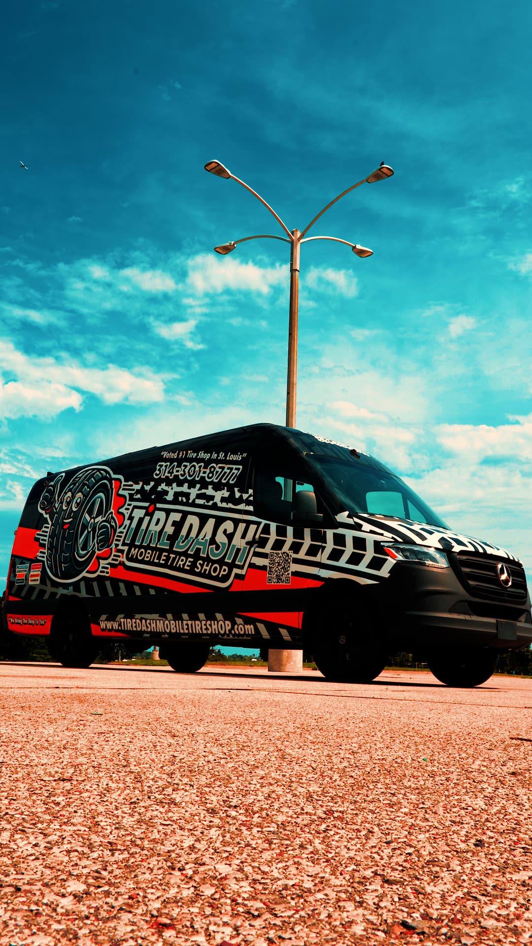 Tire Dash van under a bright blue sky, low-angle view